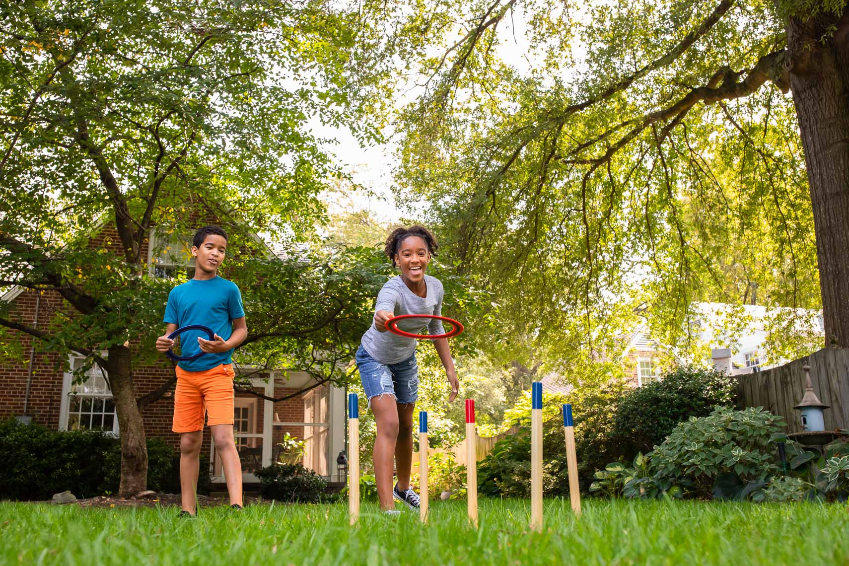 kids playing ring-toss in lush backyard_Robert_HollandPhotographer_Director
