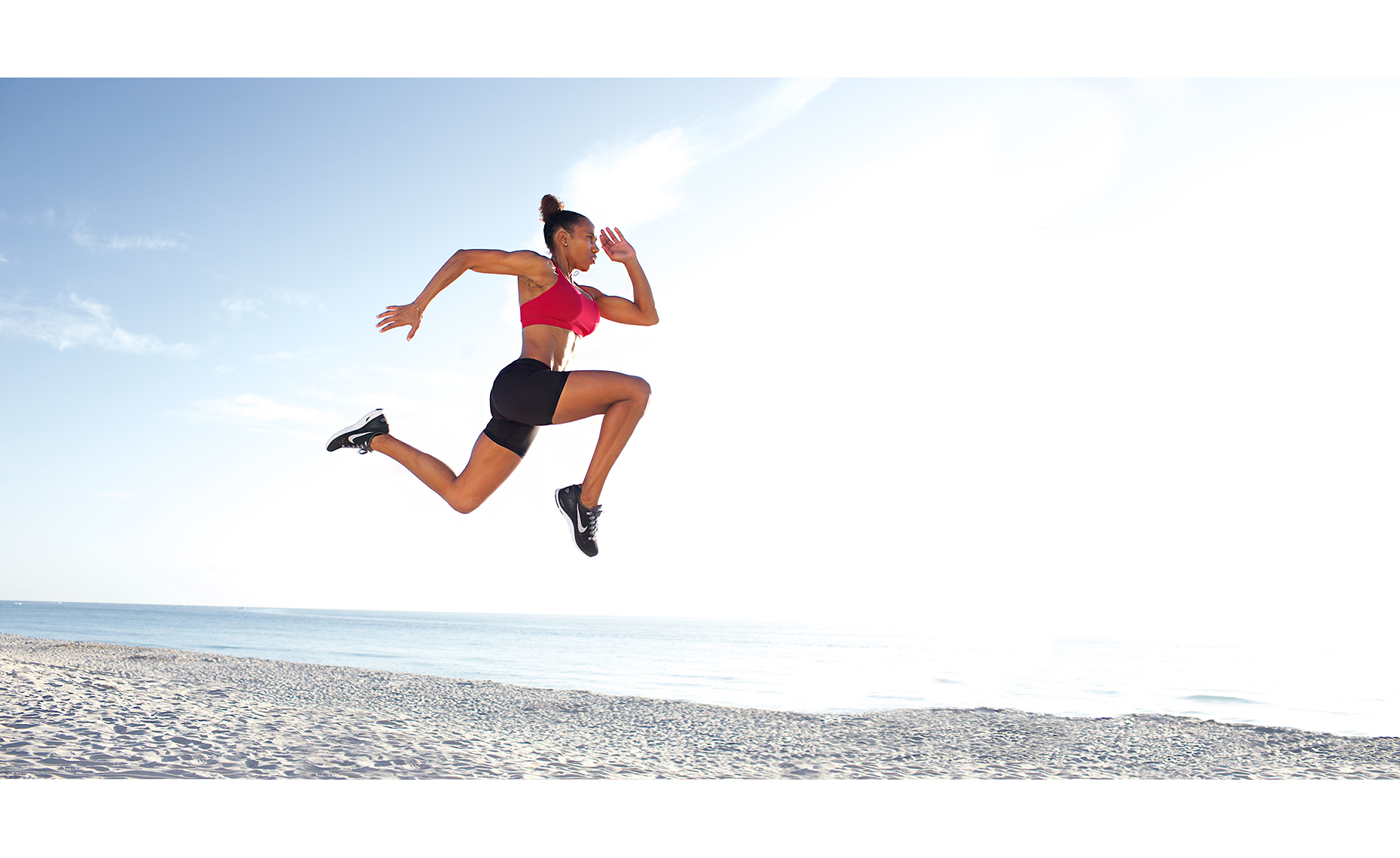 Robert_Holland_female_athlete_jumping-high-in-air-along-shore-MG_9709