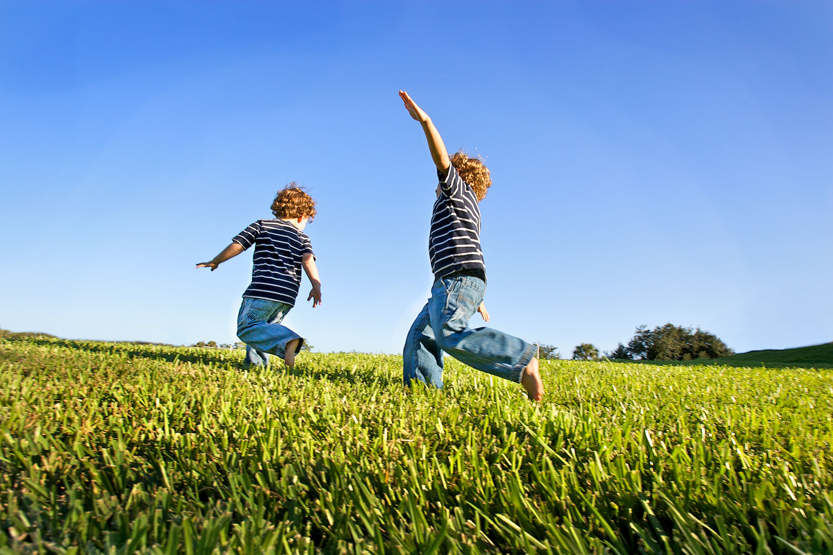 young boys running, playing airplane in field_Y0U4598_Robert-Holland.jpg