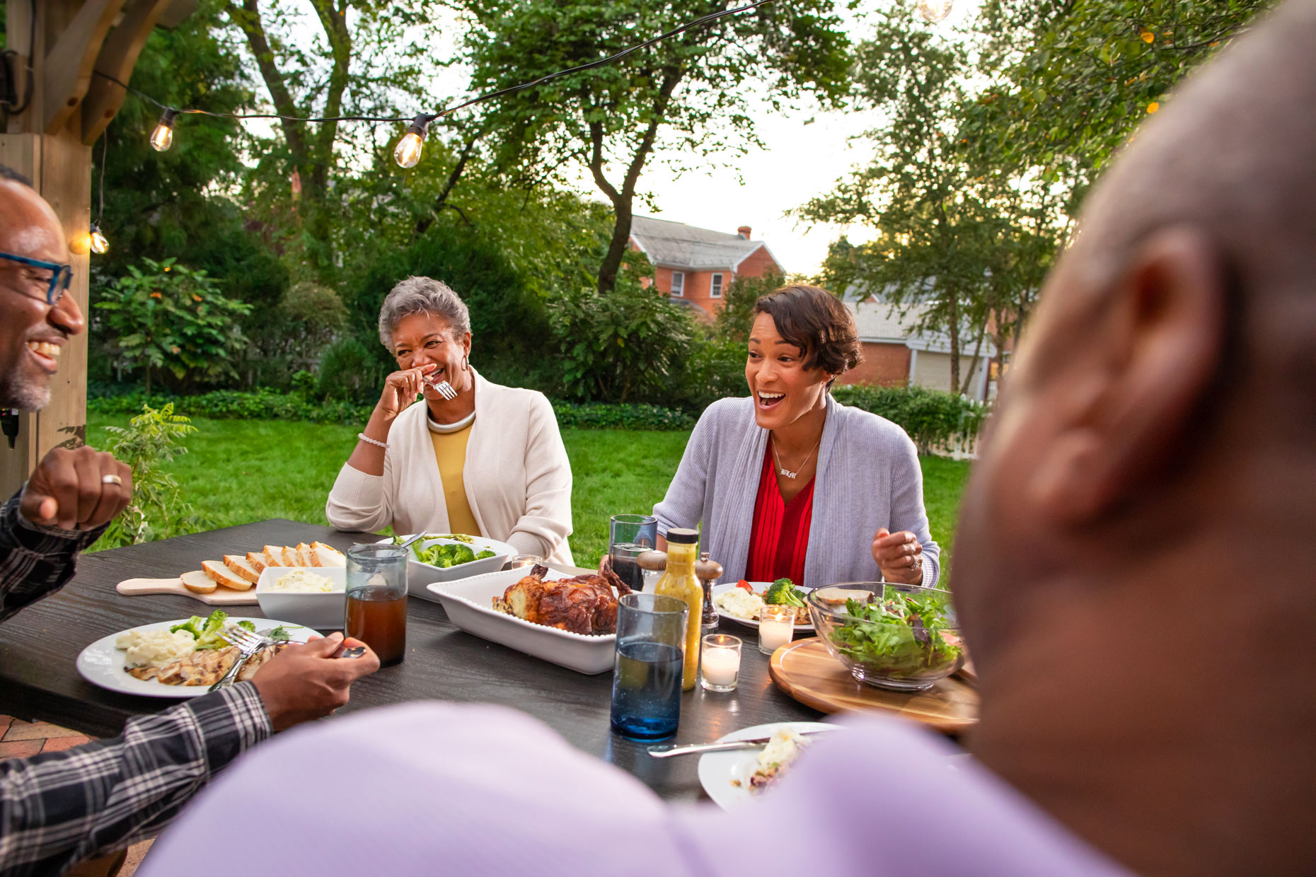 family-eating-dinner-in-backyard_Robert_Holland